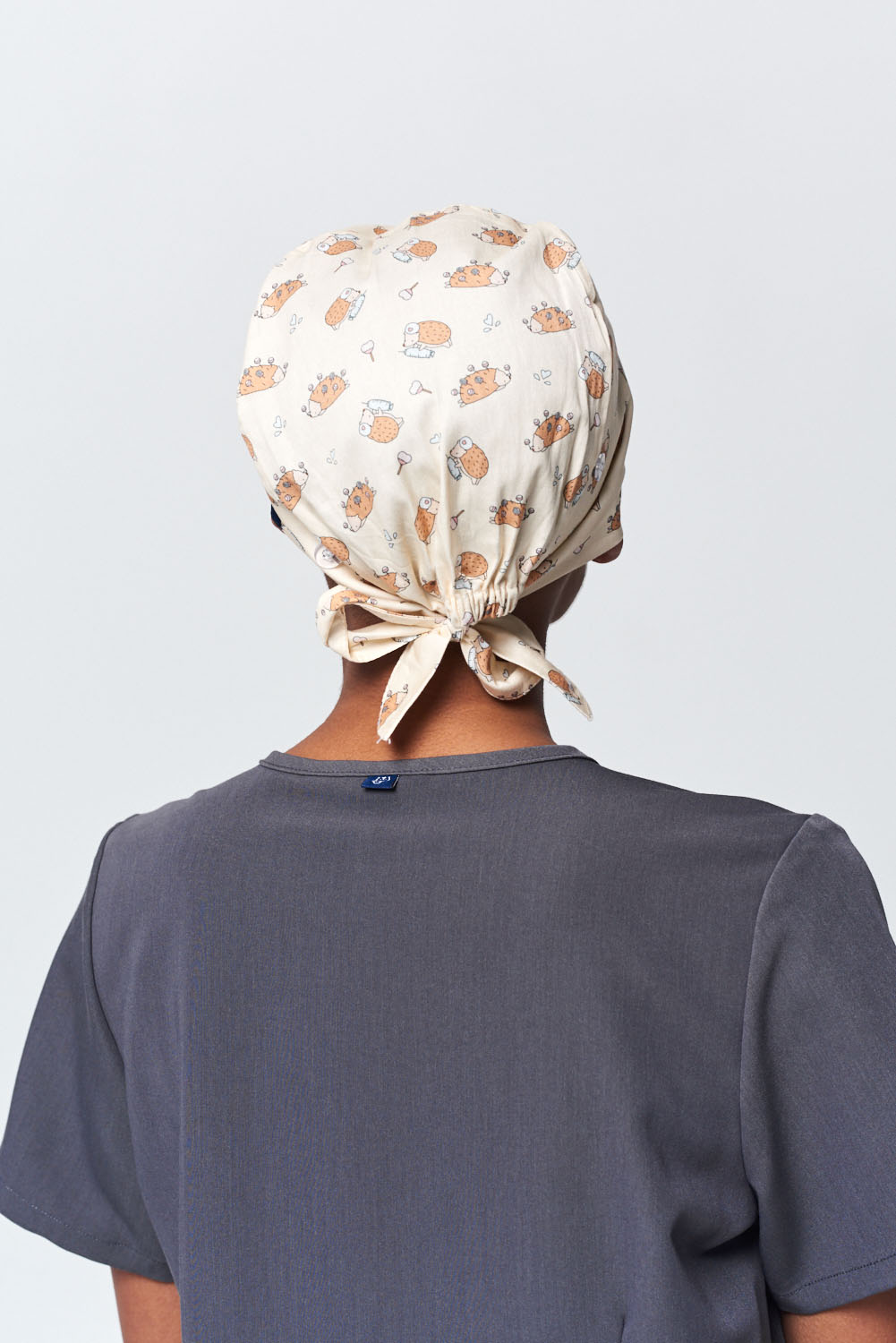 A Dentist Wearing a Dr. Woof Little Hedgehogs Surgical Scrub Cap