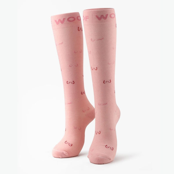 Pair of pink compression socks with line art boobs print standing against a plain background.