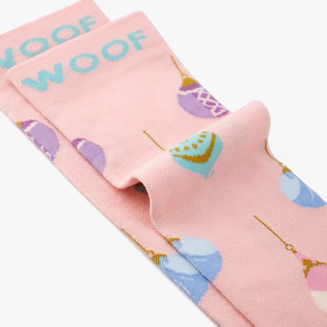A Disney Princess Christmas Bamboo Crew Compression Socks folded neatly to highlight the light blue woven "WOOF" cuff bands and the princess ornament knit pattern layout.  