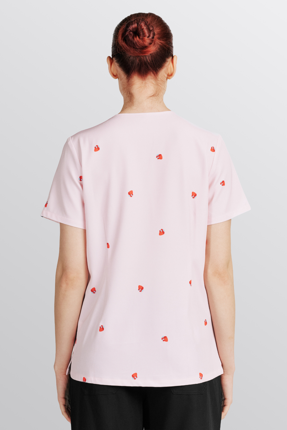 Back view of a Veterinarian wearing the light pink Lub Dub Women's 3-Pocket Scrub top with red heart pattern.
