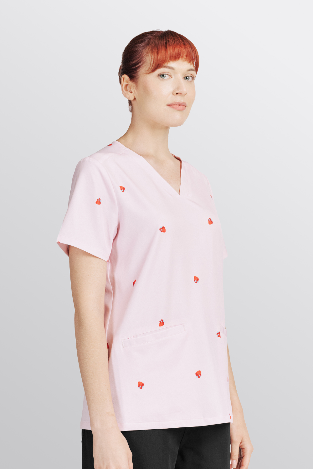 Side profile of a Doctor wearing the light pink Lub Dub Women's 3-Pocket Scrub top.