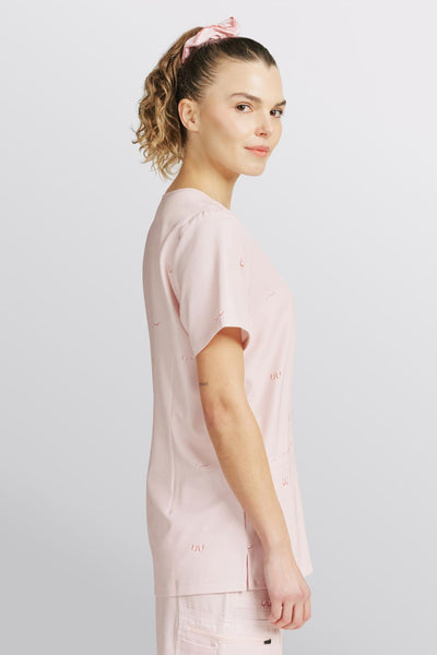 Side profile of a doctor wearing a light pink scrub top with line art boobs print.