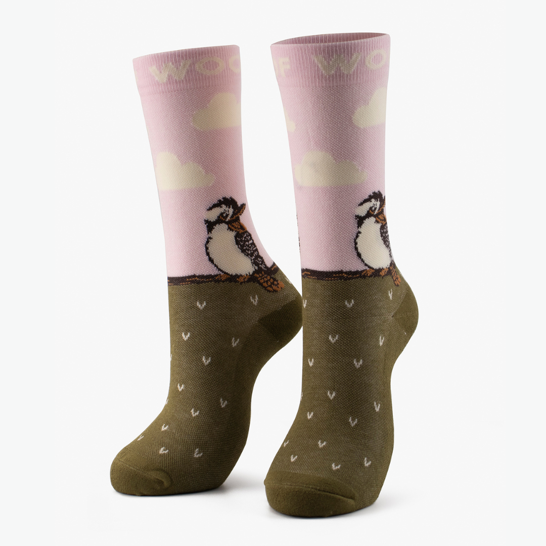 Pair of pink and olive bamboo crew compression socks with kookaburra design standing against a plain white background.