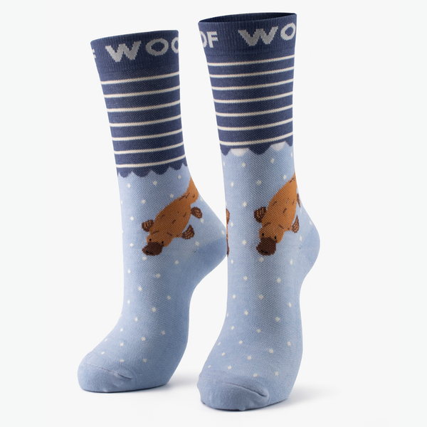 Pair of blue bamboo crew compression socks with platypus design standing against a plain white background.