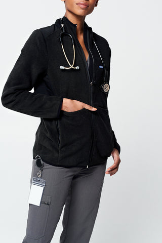 A Nurse wearing the Dr. Woof Eight Pocket Tactical Fleece Jacket over their Scrub Uniform
